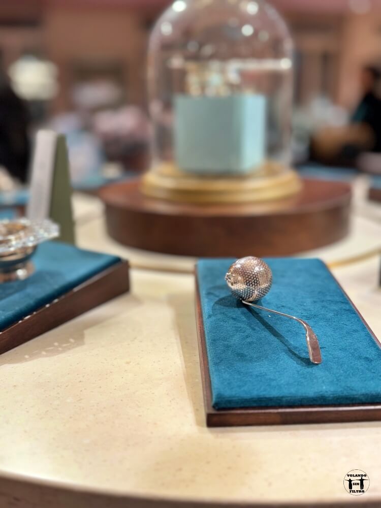 Cuchara para colocarle té en un soporte de terciopelo azul 
