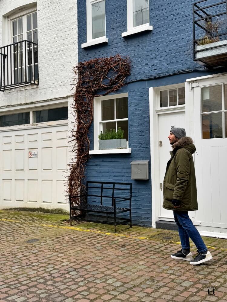 Nico delante de una fachada azul 