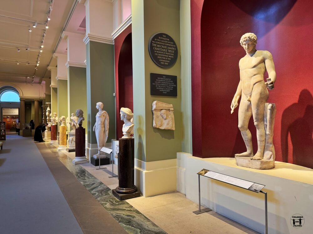 Galería del museo con figuras y esculturas en el lado izquiero