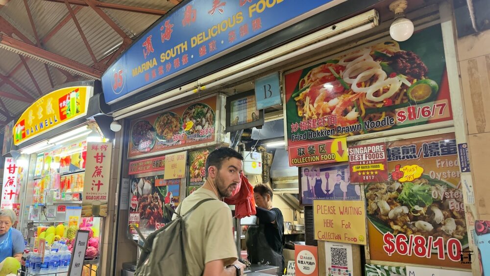 Puesto del mercado con Nico en primer plano mirando hacia atrás 