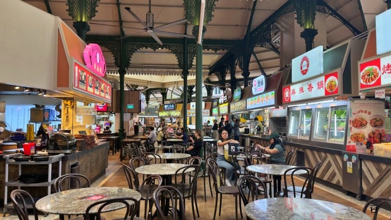 Mercado por dentro con todos los puestos y las mesas. 