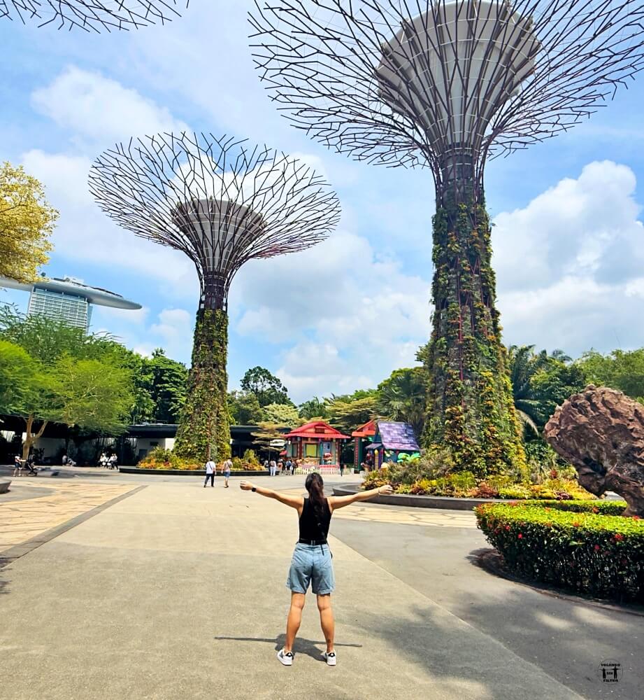 Sandra de espaldas abriendo los brazos en medio de los super tree. 