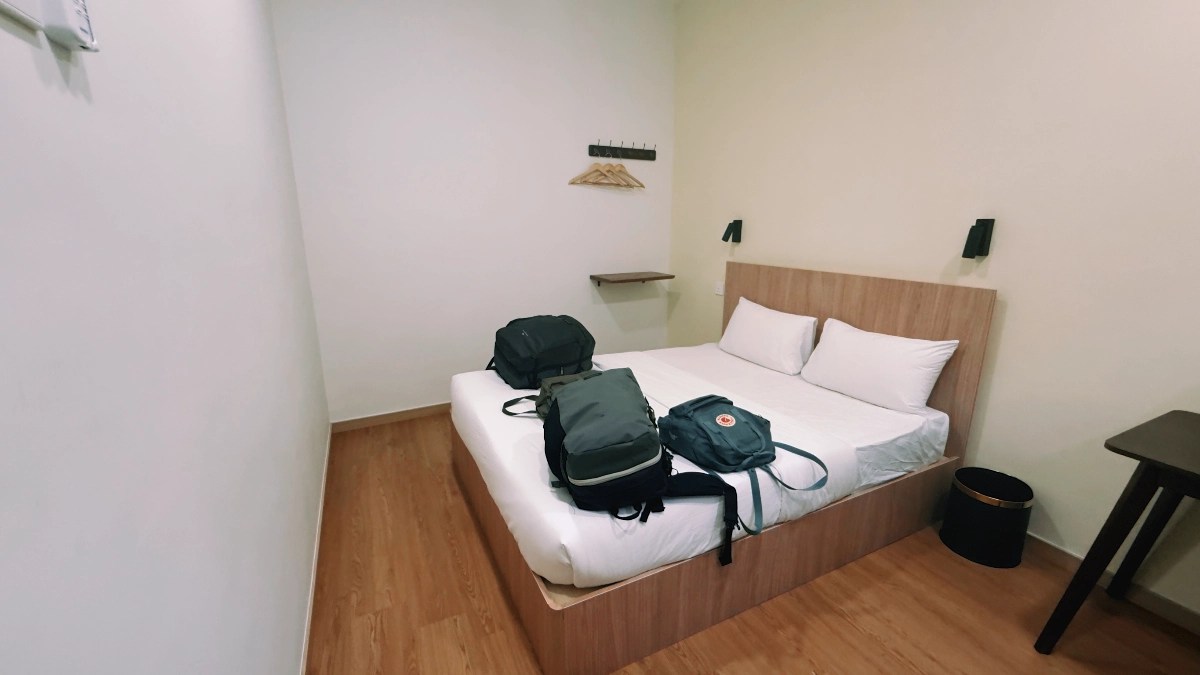 Cama en primer plano con mochilas encima