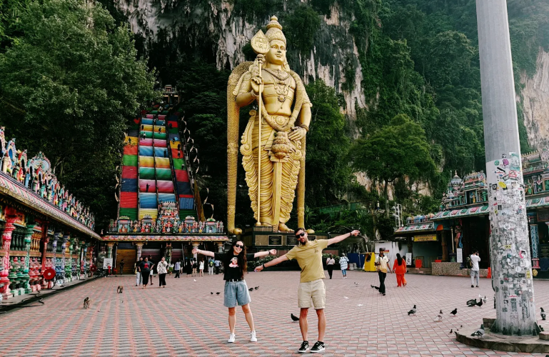 Primer plano de Nico y Sandra con las escaleras de colores de las Batu Caves de fondo