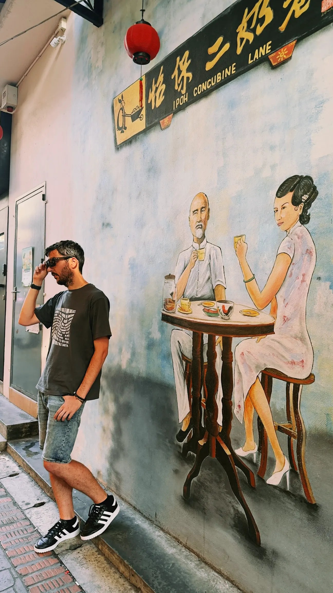 Nico en primer plano con grafiti de dos personas tomando un café