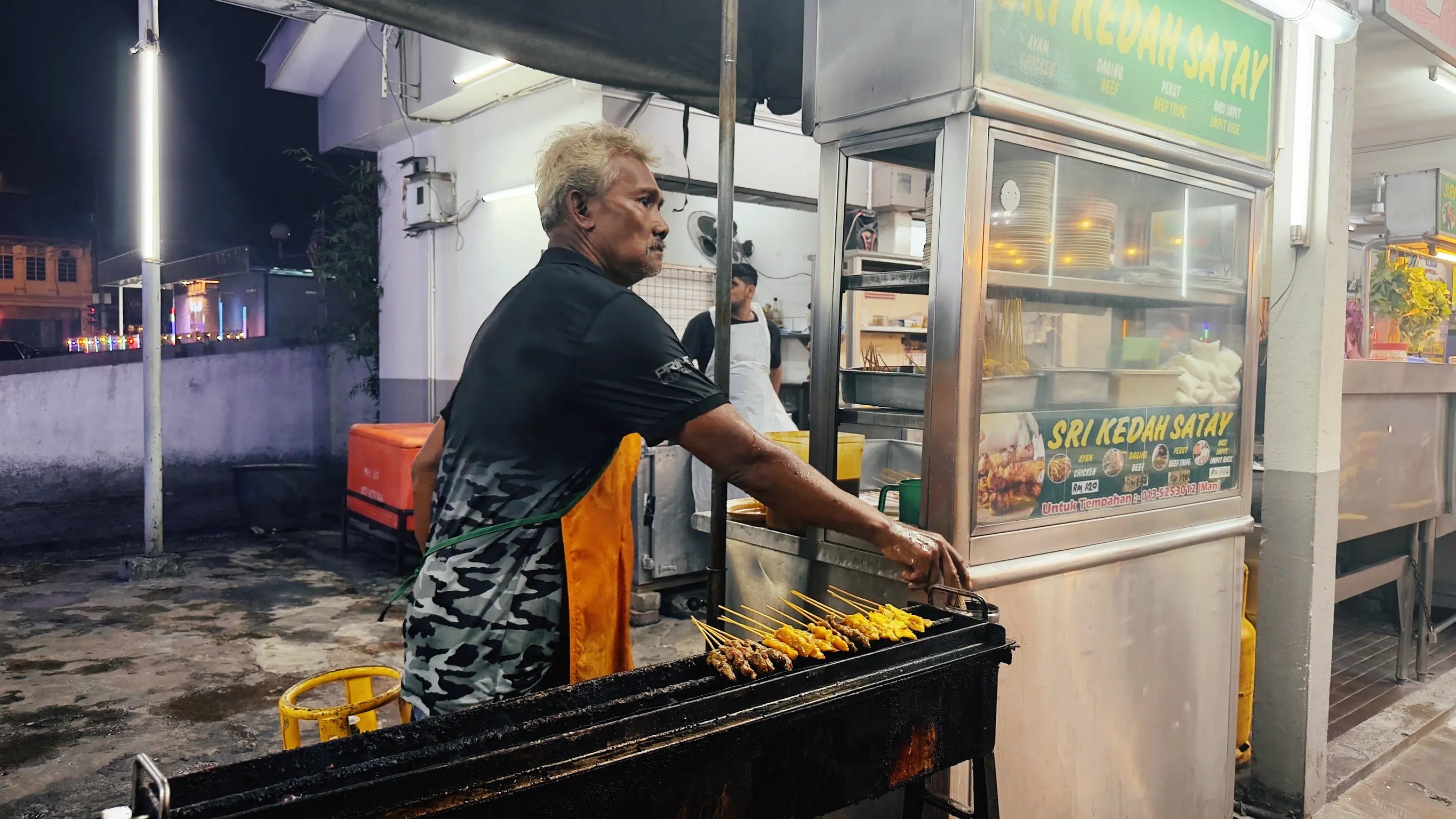 Señor cocinando en parrilla